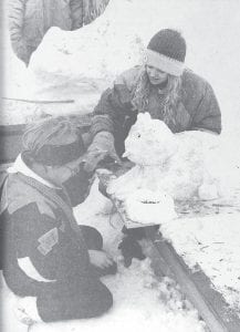 Hilja Iverson and Erica Peterson put the finishing touches on the sled dog they entered in the Dog Days snow sculpture contest in January 1991. The contest was part of a weekend-long winter carnival sponsored by the Grand Marais Chamber of Commerce in conjunction with the Beargrease 500 Sled Dog Race. The snow sculpture contest was won by Joelle Anderson and Alison Stone.