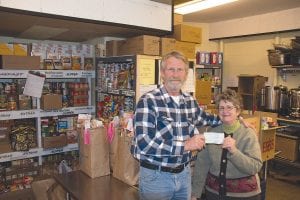 American Legion Post 413 Sons of the Legion representative David Johnson presented a check for $500 to food shelf volunteer Gwen Lenz on December 23, 2013.