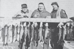 Some prize catches taken during the 1971 Trout Derby are displayed at the weigh-in station manned by, from left, Bob Frey, Don Rock and Bernard Larsen. The 14th annual event was moved from Gunflint Lake to Trout Lake due to dangerous slush conditions. The March 14 derby featured four hours of fishing and a broomball game. The winner of the contest was Joe Jurek, who won the aluminum canoe for his 4-pound, 8-ounce trout.