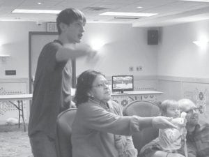 There were lots of fun family activities for the Grand Portage Elder Nutrition Program in January. Left: Wisdom Steps and the local church youth group met at the Grand Portage Lodge for an exciting evening of playing Wii. There was a friendly competition for Ben Hackett, Sylvia Manthey (seated), Youth Pastor Jake McCormick (with his son Nehemiah). Above: ENP Director Patty Winchell-Dahl attended the ENP New Year’s Eve party and enjoyed spending some time with her eldest grandson Kayne Dahl.