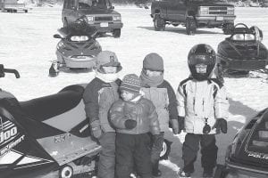 Do you recognize these kids? They were bundled up well for the March 14, 2004 Cook County Ridge Riders Snowmobile Club Trout Derby held on Gunflint Lake. Wicked winds whipped snow around the barbecue and bonfire and tipped ice houses over that year.