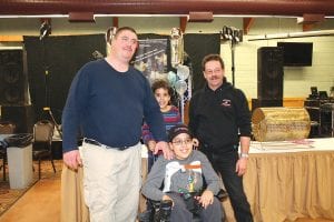 Easter Seals Ambassador Zachary Pylychuk (with his little brother Nathaniel behind) was happy to pose with the top two Snowarama fundraisers Andrew Bouley (left) and Wayne Muloin (right). The two men have a friendly competition going to see who can raise the most money to benefit Easter Seals.