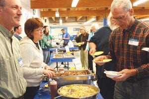 The E.A.T.S.— Enriching Academics Through Sustenance— fundraiser at School District 166 is always a festive affair with delicious samples from local restaurants. Right: Michael and Maureen O’Phelan of Cascade Resort serve up some savory pulled pork.