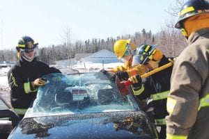 Volunteers have to complete about 140 hours of training before becoming firefighters on local departments. In addition to fighting car fires, students in the Firefighter I and II course practice extrication skills. This group practices cautiously removing a windshield with an ax, under the watchful eye of Advanced Minnesota Instructor Rob Spolar.