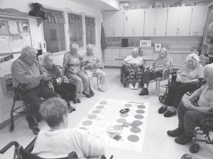 Above: The residents have given a new “twist” to the game Twister. They enjoy playing with colorful bean bags to score as many points as possible. It’s great exercise and fun, too! Left: The Bethlehem Lutheran Church Quilters recently donated seven handmade quilts to residents at the North Shore Care Center. The quilters are (L-R) Joan Beiber, Eleanor Waha, and Gladys Dockan.