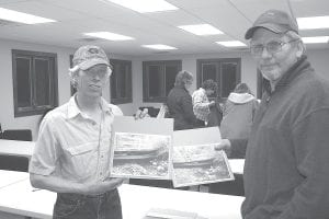 Lutsen Trailbreakers members Larry McNealy (left) and Scott Platzer made a presentation about the need for funding to repair this snowmobile trail bridge at the township annual meeting in March. Community members voted to approve $10,000 for the club. The Trailbreakers returned to the following week's meeting to accept the check. The previous bridge was built by the club in 1983.