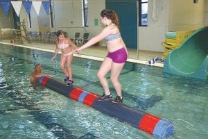 With Taylor’s dad, Tony Everson holding the log, Taylor Everson (l) gets ready to battle Wellesley Howard Larsen at logrolling practice. Both Taylor (U10) and Wellesley (U17) won medals at the Harold Fisher Logrolling tournament held at the Hudson, Wisconsin YMCA.