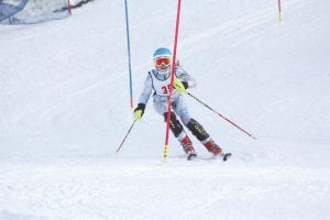 Hard charging Reilly Wahlers (upper left)) and Sela Backstrom (lower left) slash hard around the gates of a slalom course at nationals. Both girls participated in the U14 Junior National ski meet held in Winter Park, Colorado. Above: Will Lamb (left) and Logan Backstrom both raced in the U16 Junior Ski Championships held at Steamboat Springs, Colorado where this picture was taken.