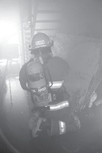 Left: Grand Marais Firefighter Mike Flack searches for the “victim” in the live burn trailer. Above: The 2014 honorees—Outstanding Emergency Services Provider Dave Gilmore and Friend of Emergency Services Award recipient Judy Sivertson—working out the kinks in emergency radio communications at the conference. This kind of work is exactly why they received the Emergency Services awards.