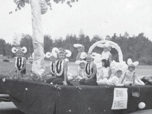 Although this float was in the Fisherman’s Picnic Parade in 1965, it had a definite spring theme. The girls were participants in the Laura Grant summer dance program and the float was called “Bears and Bunnies.” The “older” dancers were panda bears (L-R) Diane Malner, Jennifer Vervoort, Ginny Hanson (front), Mary Johnson. The bunnies, in random order were Jaymee Jackson, Tami Malner, Karen Jurek (standing), Cindy Malner (in basket), Linda Jurek, Patty Eckel (in front of basket), Lee Hansen, Debbie Toftey lying down.