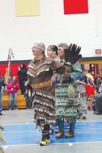 Above: The women’s jingle dresses are not just beautiful, they softly echo the sound of the drums. Right: Vivian Carlson of Grand Portage enters the arena to the sound of the Stonebridge Singers who offered an honor song during Grand Entry.