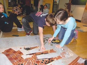 Cook County fourth-graders and some high school art students have been working on a mosaic mural to be placed on the west wall of Johnson’s Grocery building. The mosaic design incorporates the Grand Marais harbor, a waterfall, lakes, swamps, woodlands and numerous animals. It is hoped that the mural will be in place by mid-summer.