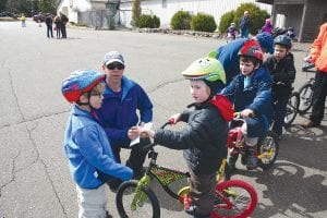 With Dave Tersteeg kneeling and looking on, Juniper Cefalu (on bike) gets some last minute instruction from Ian Cooley as he prepares to participate in the Bike Rodeo. Kids got their helmets fitted and bikes checked and took part in a bike safety riding class in the rodeo held at the Cook County Community Center parking lot on Tuesday, May 13.