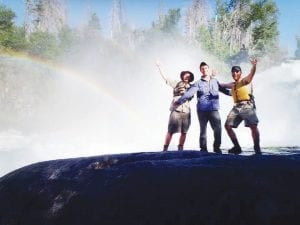 Pictured on their last great canoe adventure with water and rainbows behind them are (L-R) Adam Maxwell, Jake Bendel and Ryan Ritter. The adventurers celebrated the beauty surrounding them. The threesome will be joined by three others on their next two-month long canoe trip into the Canadian wilderness. Bendel and Maxwell are former employees of Voyageur Canoe Outfitters.