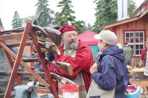 Traditional artisans were demonstrating their craft on campus. Left: The blacksmith shop heard lots of hammering. Above: Brent Gurtek, the instructor of a traditional gunsmithing course at North House answers questions about the guns he has crafted.