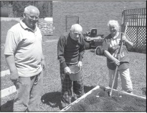 Sweeney Croft planted potatoes in garden boxes with some help from his family Lynetta and Sheldon Houglum.