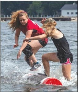 A strong wind whipped the water and log rollers at the Midwest Logrolling Championships held June 28 in Madison, Wisconsin. Wellesley Howard Larsen (left) of the Cook County Community YMCA North Shore Rollers sends Hayward’s Maggie Penning into the water in the championship match. Penning won 3 falls to 1.