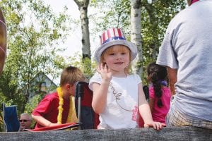 Left: Walking or riding, kids were having a great time in the Tofte parade. Above: This little girl was having a great time in the Tofte parade with her patriotic pom-poms.