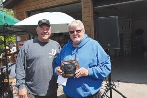 After a ride in the Tofte parade, former Tofte Supervisor Allan “DC” Olsen (right) was presented a plaque declaring him the 2014 Tofte Citizen of the Year. Town Board Chair Paul James made the presentation, thanking Olsen for his many years on the town board and for his work as the township liaison for the Birch Grove Community Center.