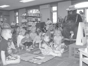 Smokey Bear dropped by the Grand Marais Public Library on Tuesday, July 15 to share some stories and lessons about “good fires” and “bad fires,” and of course, to celebrate his 70th birthday with a scrumptious cake and some new-found friends. The ursine celebrity is seen here enjoying the presentation with a group of fascinated children.