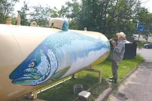 That’s a keeper! Local artist Betsy Bowen spent her Fourth of July weekend painting this lake trout onto the very large propane tank at Como Oil & Propane in Grand Marais. Funds for the project came from the Moving Matters “Great Place Race.”