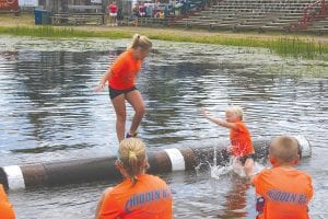 Top left: Paige Everson sends one of her competitors into the drink. Lower left: Lucy Shaw and Robin Henrickson battle to advance in the U-13 girl’s division at the Lumberjack World Championships. Above: Getting all of the North Shore Rollers together for a picture is all but impossible. Here are most of the team that participated in the Lumberjack World Championships. (L-R) Jenny Atkinson, Brandi Colman, Paige Everson, Taylor Everson, Lucy Shaw, Bear Atkinson, Dominick Wilson and Luke Johnson.