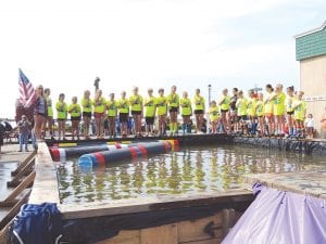 Logrollers stand at attention for the national anthem at the opening ceremonies for the Minnesota State Logrolling Championships held over the Fisherman’s Picnic weekend.