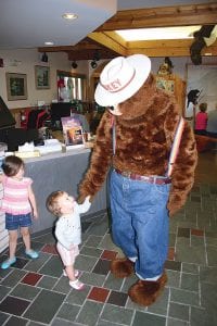 With her older sister looking on, Mary Mueller takes a paw and looks adoringly at Smokey Bear. The Mueller sisters and their father Justin were part of a larger crowd that came to wish Smokey a happy 70th birthday. The party was held at the Gunflint Ranger Station on Saturday, August 9. Another birthday party was also held at the Tofte Ranger Station on Sunday.