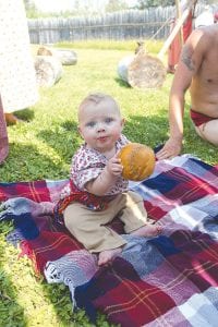 This baby enjoyed playing with a hand stitched lacrosse ball while her father played a rigorous game of lacrosse on the lawn.