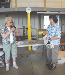 The Mid-Gunflint Trail Auction, Flea Market, Boutique and Quilt Raffle was the place to be on Thursday, August 7. Top: There was an amazing assortment of items, many handcrafted by Gunflint Trail residents, to purchase at the Schaap Community Center. Above left: Fire Chief Jim Morrison thanked the Mid-Gunflint property owners for their support and talked about how funding from the auction event is put to use. Above right: Organizers Lee Zopff and Tersenia Schuett get ready to draw the winning raffle ticket. Darlene Katajamaki was the lucky winner of the special quilt titled Vintage Triangles. It was created by the Mid-Trail quilters