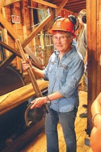 Above: History is celebrated on John Schroeder Day with a glimpse into the sawmill of Dion and Tony Cicak. Dion shows off a cant hook used to move logs. Upper left: Skip Lamb led a history walk past this old barn, which is on the National Registrer of Historic Places. Lower left: The history walk takes a look at the Cross River Bridge and Father Baraga Cross.