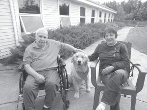 Dogs are welcomed visitors at the North Shore Care Center any day of the year. Marcia Lacey, dog trainer and owner of a golden retriever named Charlie spent time with elders on the patio on Labor Day. (L-R) Bob Heideman, Charlie, and Marcia.