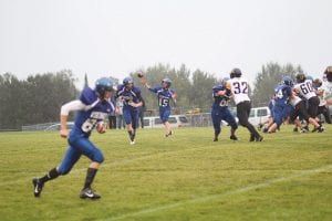 Left: Defended by Noah Warren (62), Viking quarterback Leo Johnson fired a pass to Jack Wieben who turned and caught the ball for a short gain while Andy Farley (81) ran a deep route. Below: Slipping one tackle, Jack Wieben lowered his shoulder to run over this would-be Marshall tackler and scored on a long touchdown run in the third quarter. Wieben powered in for another touchdown on a short yardage play late in the game. Below left: Breaking a tackle after a nice catch, Owen Anderson ran the length of the field for a touchdown on this play.