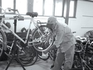 WOW (Workers on Wheels) volunteer Lynn Wright inspects one of the approximately 60 bikes available for the international workers that visit Cook County each year. The WOW program, in its fifth year, gives visiting workers transportation during their stay and gives WOW volunteers the chance to get to know some of the guest workers.