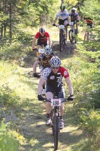 Left: The race included a new route on recently improved single-track trails at Pincushion Mountains. Above: Riding on fat tires, Adam Harju (296) finished second in the 15-mile sport race, while John Twiest (middle) placed 7th in the 21-mile expert class race. Nancy Rova (right) won the women’s division of the 15-mile race.