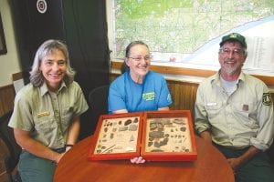 Marlene Platcek (middle) recently donated artifacts found by her late husband Eldon to the U.S. Forest Service. Eldon lived in Cook County in the early 1960s for three years and spent much of his time combing the woods and watershed beaches for tools or spear points used by early nomadic people. A meticulous record keeper, Eldon documented sites still unknown to the Forest Service. Accepting the collection from Marlene were Forest Service employees Suzanne Cable and Tom Kaffine.