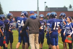 Left: Assistant Coach Mike Boomer gathers his team around him and tries to rally them. Below: Rory Bakke scampers for a long run. Bakke scored the Vikings’ lone touchdown against Hinckley-Finlayson. The Vikings lost the game 37-8 and are now preparing to face East Central on Sept. 21 at Sandstone.