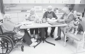 Residents baked dog biscuits for the Resident Council Holiday Sale. (L-R) Bernice LeGarde, Donna Willett, Whitey Dockan, Skip Rouser, and the dog Awesome, lending his seal of approval.