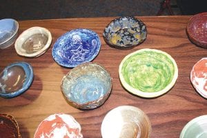 Above: Local artisans and school kids donated their time and skill to make a great variety of colorful bowls for the Empty Bowls fundraiser held at St. John’s Catholic Church in Grand Marais. Left: Jeff Wenz (left) and Stan Tull were two of the many volunteers that worked to make Empty Bowls a success.