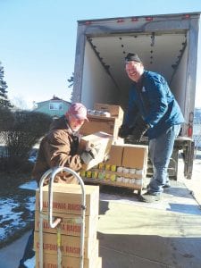 Above: Getting an assist from the Second Harvest truck driver, Ken Bartz off loads a pallet of food that he took into the food shelf located in the basement of the First Congregational Church in Grand Marais. Left: Ann Russ (left) and Jean Bartz fill up the nearly empty shelves at the food shelf. With winter coming there is more need for food in the community as families and individuals run short of money needed to pay for heat and warm clothing, among other things.