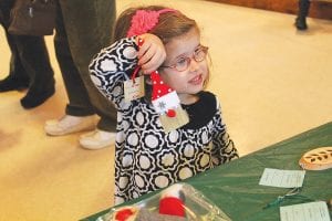 This little girl was tickled by the paintbrushes turned into Santa ornaments.