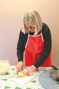 Suzan From at the Cross River Heritage Center carefully creates a delicious krumkake. The heritage center in Schroeder was also the scene of Christmas festivities.