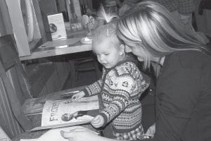 This little girl and her mom check out the Silent Auction items, including a Frozen storybook.