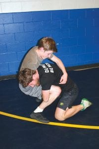 Jay Arrowsmith DeCoux demonstrates a take down move to Finn Gary on the first day of wrestling practice.