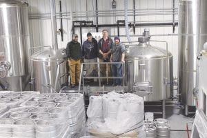 Taking a break from setting up the gleaming new tanks and tap lines are members of the Voyageur Brewing Company “Dream Team.” (L-R) Co-owner Bruce Walters, Brew Master Jason Baumgarth and Anders Johansen and Eric McCormick of Turnkey Brewery & Restaurant Consulting of Portland, Oregon.