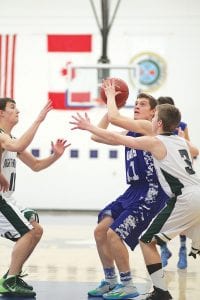 Left: With his“eyes on the prize,” Rory Bakke ignored the defense around him and scored 2 of his 13 points against Northeast Range. Above: Jared Spry (No. 24) had a tall order when he shot over this defensive player from McGregor. Spry scored 5 points in the game.