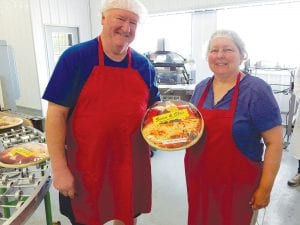 Sid Backlund and Dolly Smith display one of the many frozen pizzas the company hopes to sell throughout portions of a five-state area. Sid and Dolly have spent many long hours and traveled many long miles over the last three years to make this project happen. The pizzas will be made in Siren, Wisconsin and delivered to market by Upper Lakes Foods.