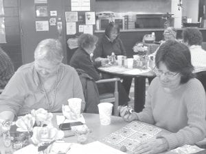 Above: Sisters Gale Carlson and Sally Gagnon enjoyed a special Valentine’s Day bingo. They were not as lucky as the table behind them. Everyone at that table was a winner in the “coverall” bingo. Left: Dottie Griffith was pretty lucky at the Valentine’s bingo. She shows off some of her prizes.