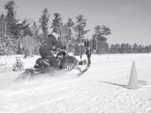 Above: The Cook County Ridge Riders Snowmobile Club held snowmobile drag races on Hungry Jack Lake on Saturday, Feb. 14. These hardy folks did not let the -14 degree temperatures keep them from competing! Left: Congratulations to Greg Grescyzk of Grand Marais who took home some nice trophies for 1st place in the 700, 800 and Open Class divisions. Below: Snowmobilers enjoyed being on the lake and on the trails.