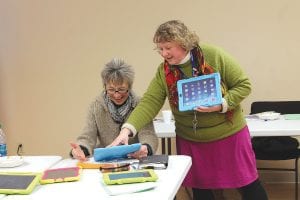 School District 166 Teacher Natalie Shaw shows School Board Member Deb White how her first-grade students use I-Pads. The school board had a good time at the March 5 board meeting, checking out the educational programs used by kindergarten through third-grade students at Sawtooth Mountain Elementary.